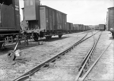 807314 Afbeelding van een wissel op een onbekend emplacement van de Staatsspoorwegen, met enkele gesloten goederenwagens.